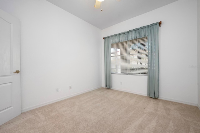 empty room featuring baseboards, light carpet, lofted ceiling, and a ceiling fan