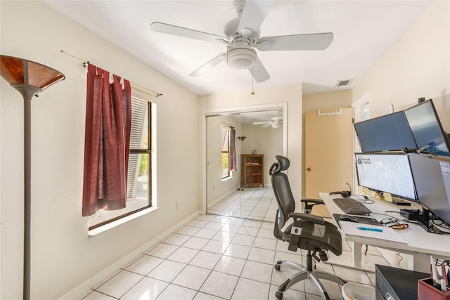 home office with light tile patterned floors, visible vents, baseboards, and ceiling fan