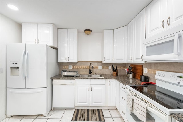 kitchen featuring a sink, backsplash, white appliances, white cabinets, and light tile patterned floors