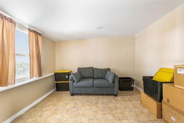 living area featuring light tile patterned flooring and baseboards