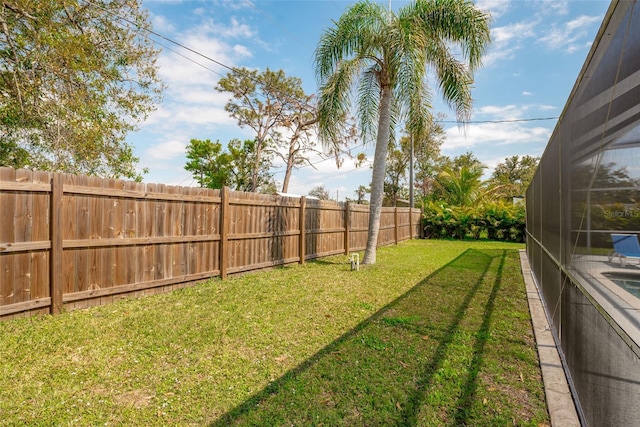 view of yard with a lanai and a fenced backyard