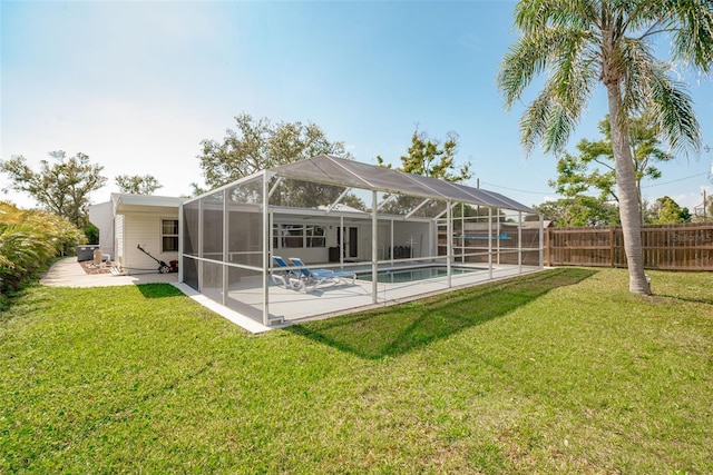 back of property with a yard, a fenced in pool, a patio, and fence