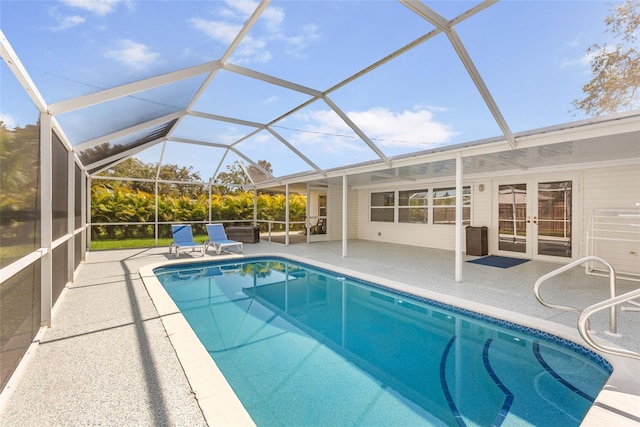 outdoor pool featuring glass enclosure, a patio, and french doors