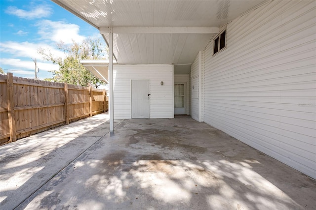 view of patio / terrace with a carport and fence