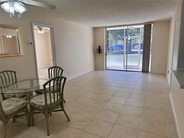 unfurnished dining area with expansive windows, light tile patterned floors, a ceiling fan, and a textured ceiling