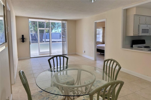 dining room with light tile patterned floors, a textured ceiling, and baseboards