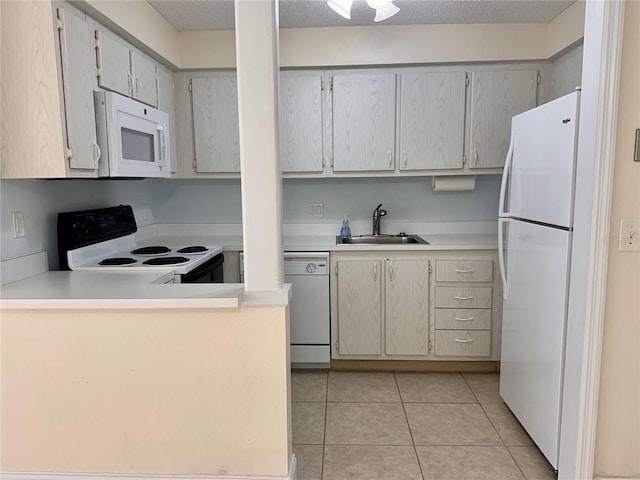 kitchen featuring a sink, white appliances, a peninsula, light tile patterned flooring, and light countertops