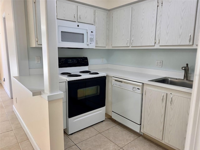 kitchen with a sink, white appliances, light tile patterned flooring, and light countertops