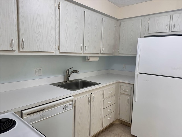 kitchen with white appliances, light tile patterned floors, light countertops, and a sink