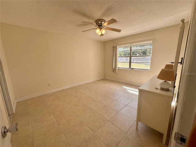 spare room featuring light tile patterned floors, baseboards, a textured ceiling, and ceiling fan