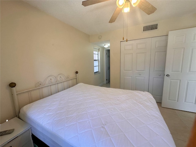 bedroom featuring a ceiling fan, visible vents, a closet, and a textured ceiling