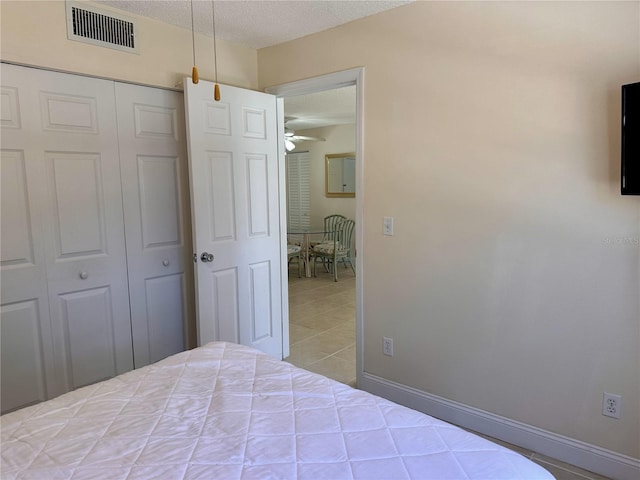 unfurnished bedroom with a closet, visible vents, a textured ceiling, and baseboards