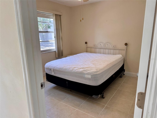 bedroom with light tile patterned floors and baseboards