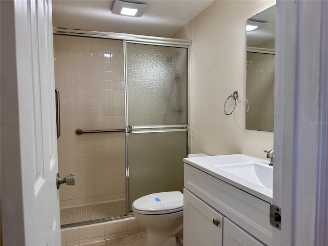 full bath with tile patterned flooring, toilet, a stall shower, a textured ceiling, and vanity