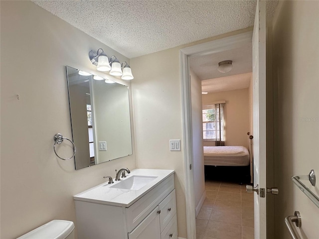 bathroom with vanity, toilet, tile patterned flooring, and a textured ceiling