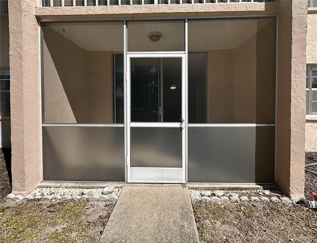 entrance to property featuring stucco siding