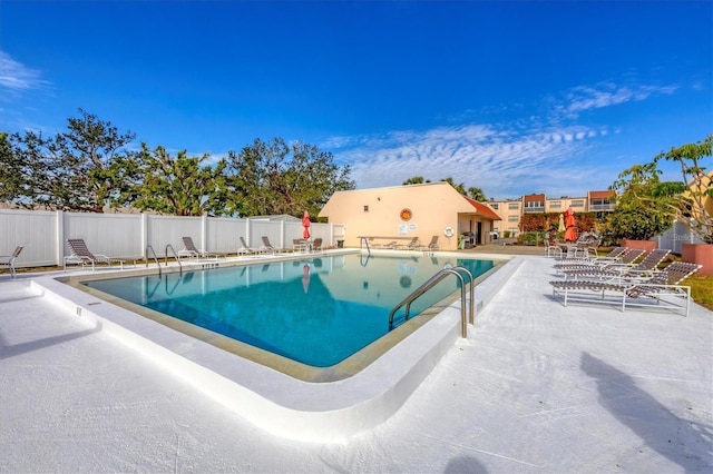 pool with a patio area and fence