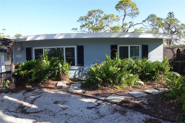 view of front facade featuring concrete block siding and fence