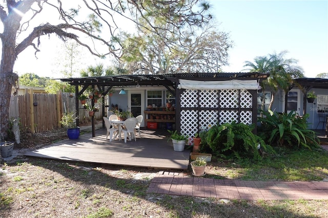 exterior space featuring a pergola, a wooden deck, and fence