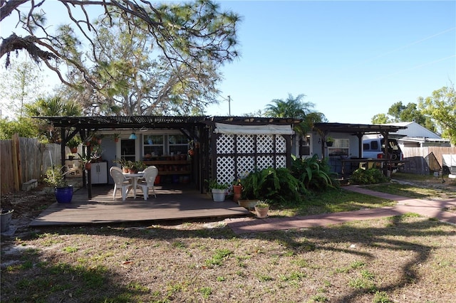 rear view of house with a deck, fence, and a pergola