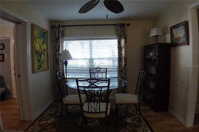 dining room with baseboards, light wood-type flooring, and ceiling fan