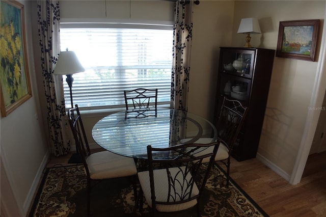 dining room with baseboards and wood finished floors