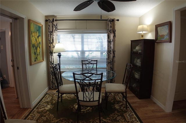 dining space with light wood-style flooring, baseboards, and ceiling fan