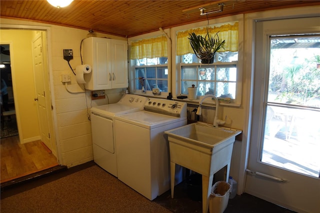 laundry area featuring wood ceiling, washing machine and dryer, plenty of natural light, and cabinet space