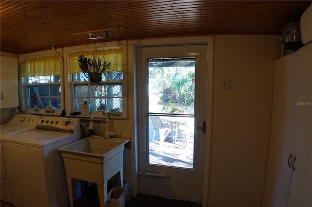 clothes washing area featuring separate washer and dryer, cabinet space, wood ceiling, and a sink