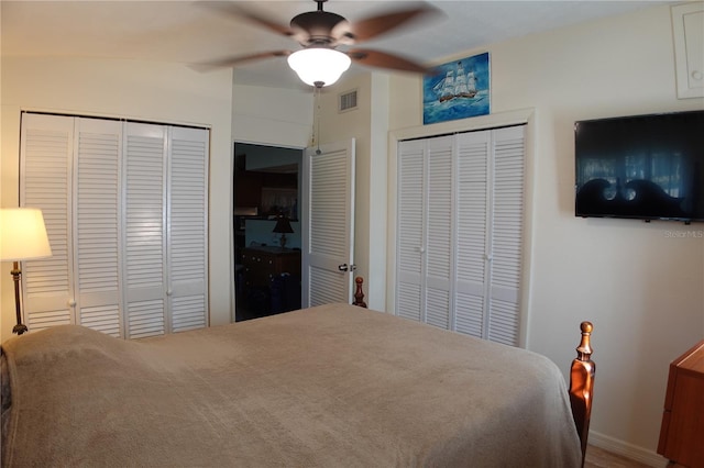 bedroom with visible vents, multiple closets, and ceiling fan