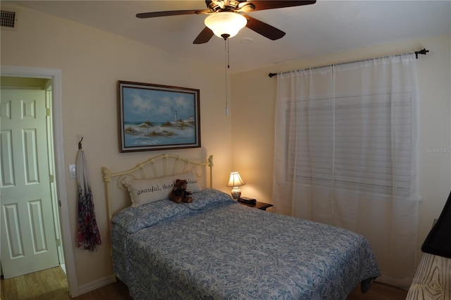 bedroom with visible vents, a ceiling fan, and wood finished floors