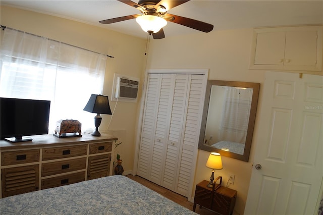 bedroom featuring a closet, a ceiling fan, and a wall unit AC