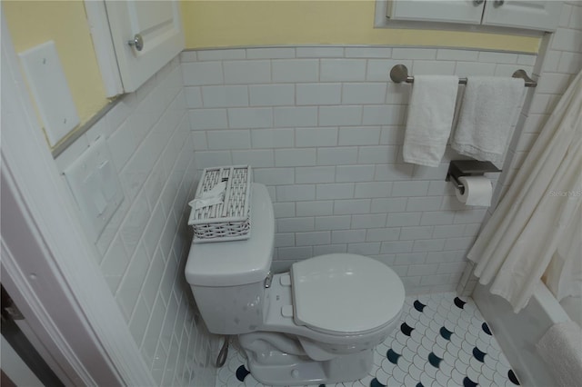 bathroom featuring tile patterned flooring, tile walls, and toilet