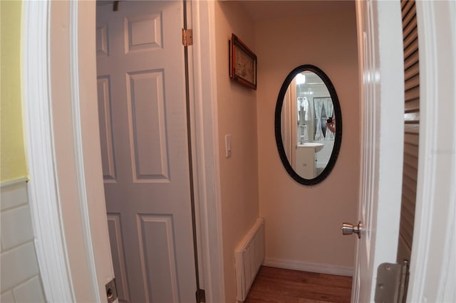 hall featuring radiator heating unit, wood finished floors, and baseboards