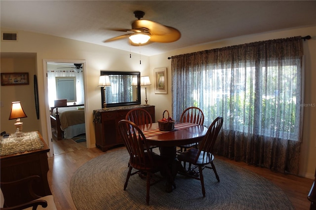 dining room with visible vents, light wood-style floors, a ceiling fan, and vaulted ceiling