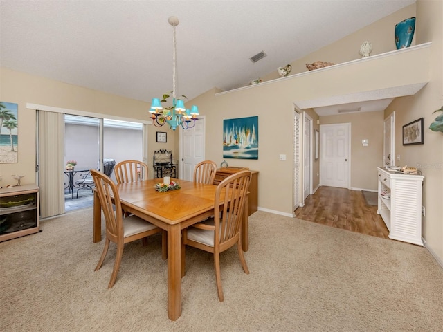 dining area featuring carpet floors, visible vents, vaulted ceiling, and a chandelier
