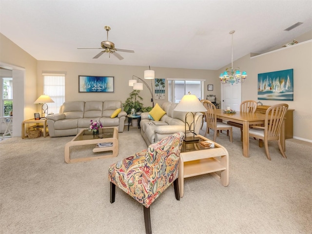 living area with visible vents, ceiling fan with notable chandelier, and light colored carpet