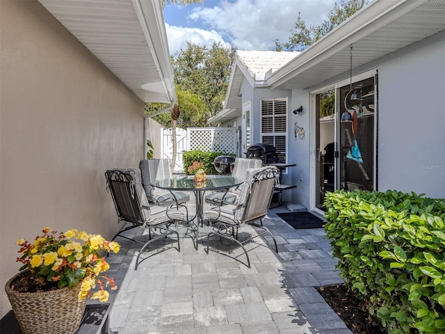 view of patio with a gate, fence, and outdoor dining space