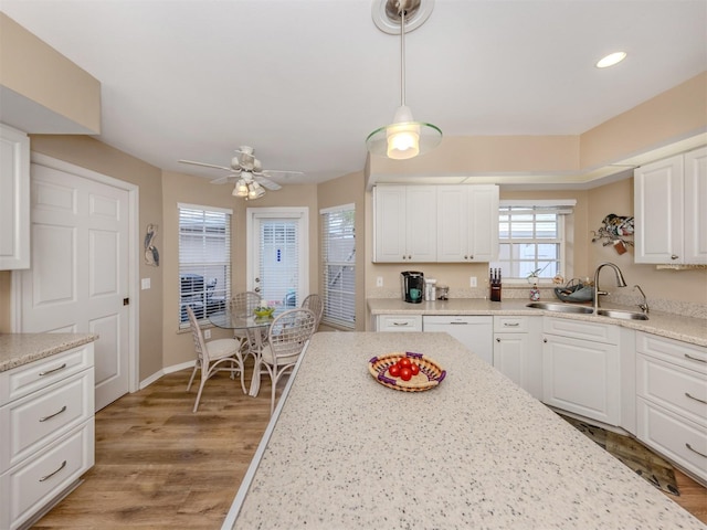 kitchen with a ceiling fan, white cabinetry, a sink, light wood-type flooring, and white dishwasher