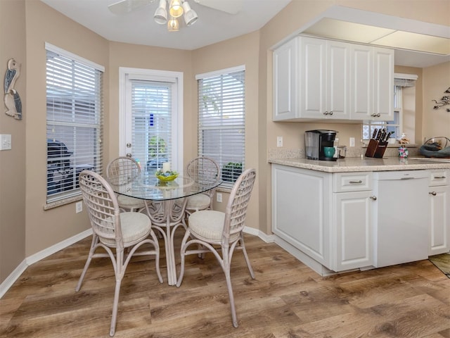 dining area with baseboards, light wood-style floors, and a ceiling fan