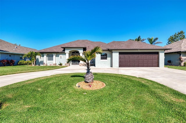 view of front of house featuring a front yard, an attached garage, driveway, and stucco siding