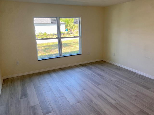 empty room featuring wood finished floors and baseboards