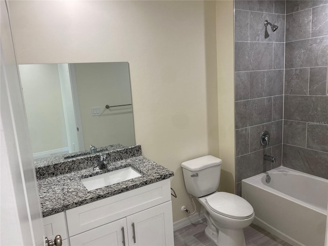 bathroom featuring vanity, toilet, bathing tub / shower combination, and baseboards