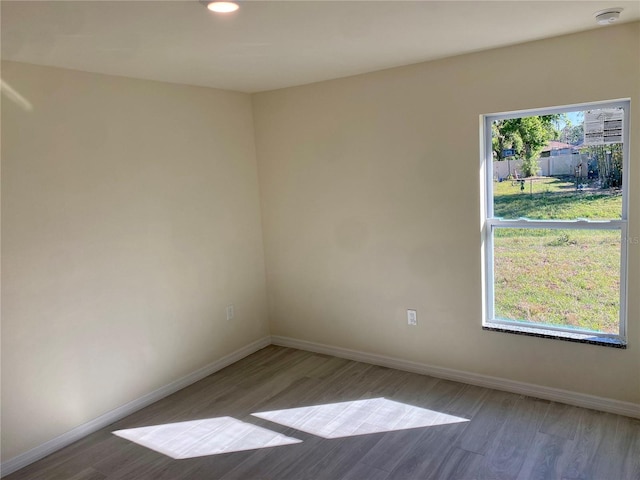 spare room featuring recessed lighting, baseboards, and wood finished floors