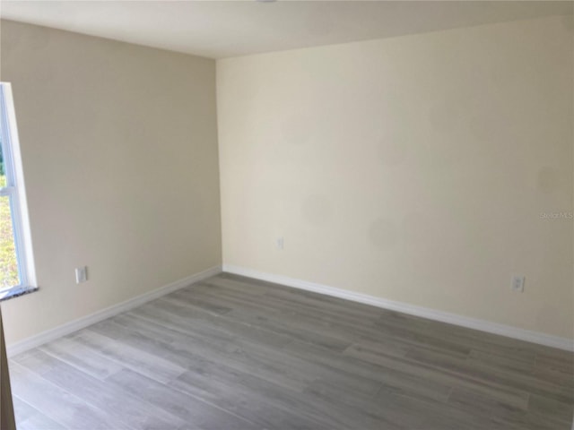 empty room featuring wood finished floors and baseboards