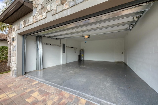 garage featuring electric panel, secured water heater, and a garage door opener