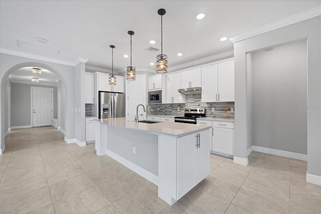 kitchen with arched walkways, a sink, stainless steel appliances, crown molding, and backsplash