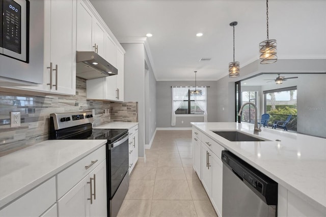 kitchen with ornamental molding, a ceiling fan, under cabinet range hood, a sink, and appliances with stainless steel finishes