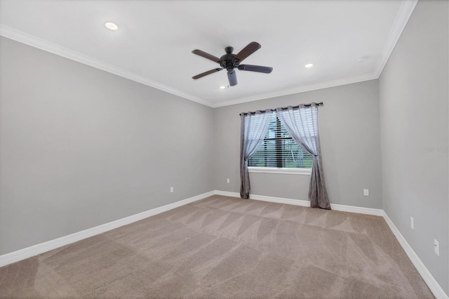 empty room featuring light colored carpet, baseboards, a ceiling fan, and crown molding