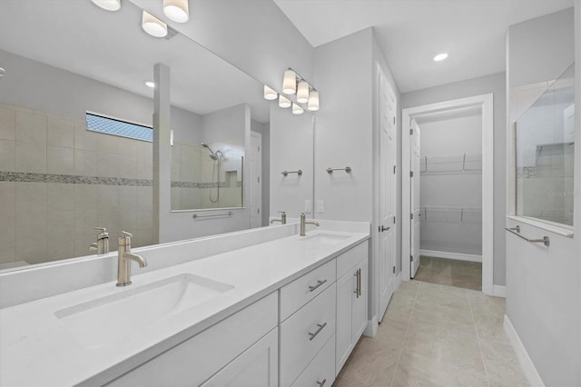 full bathroom with double vanity, tile patterned floors, a walk in shower, and a sink